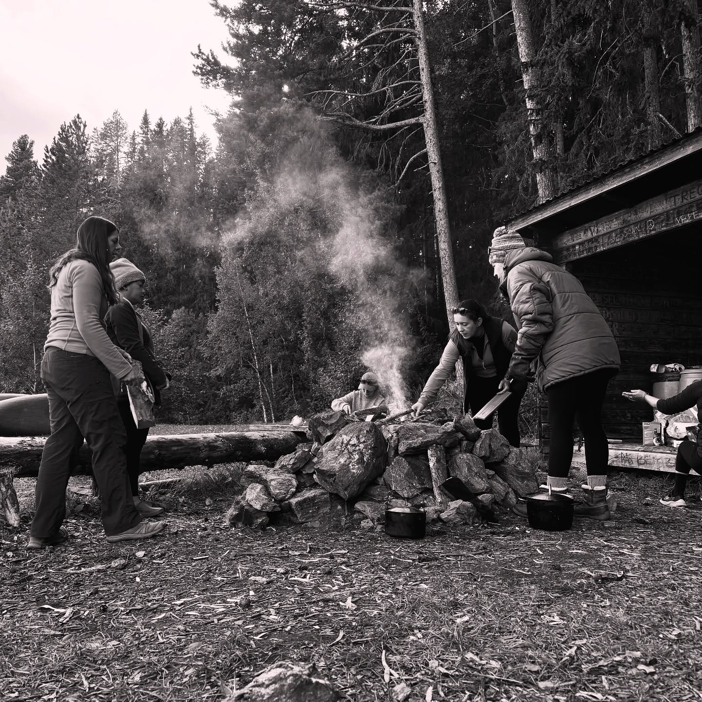 Cooking over a campfire in the forest, black and white