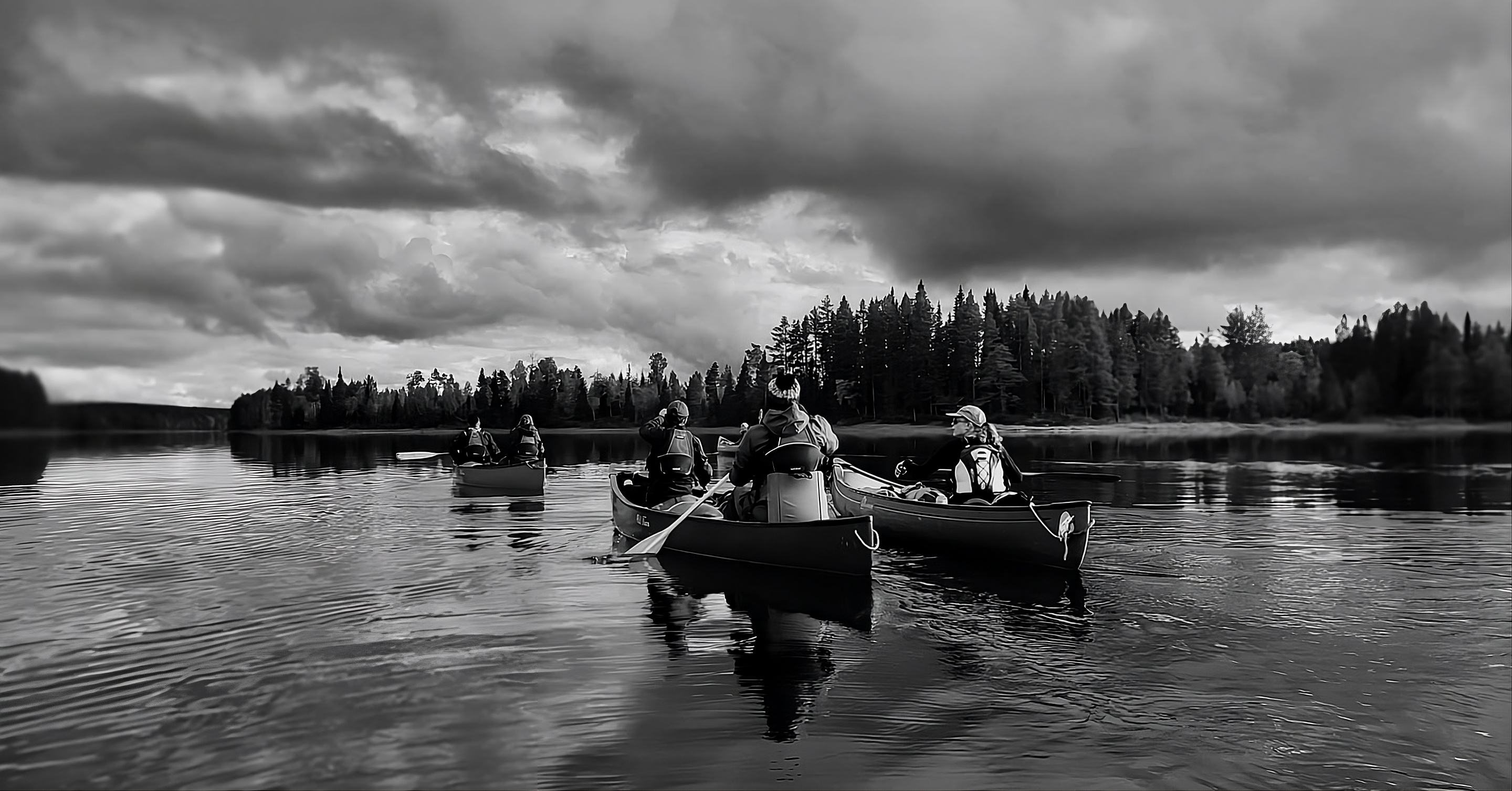 Canoes on a calm lake in black and white