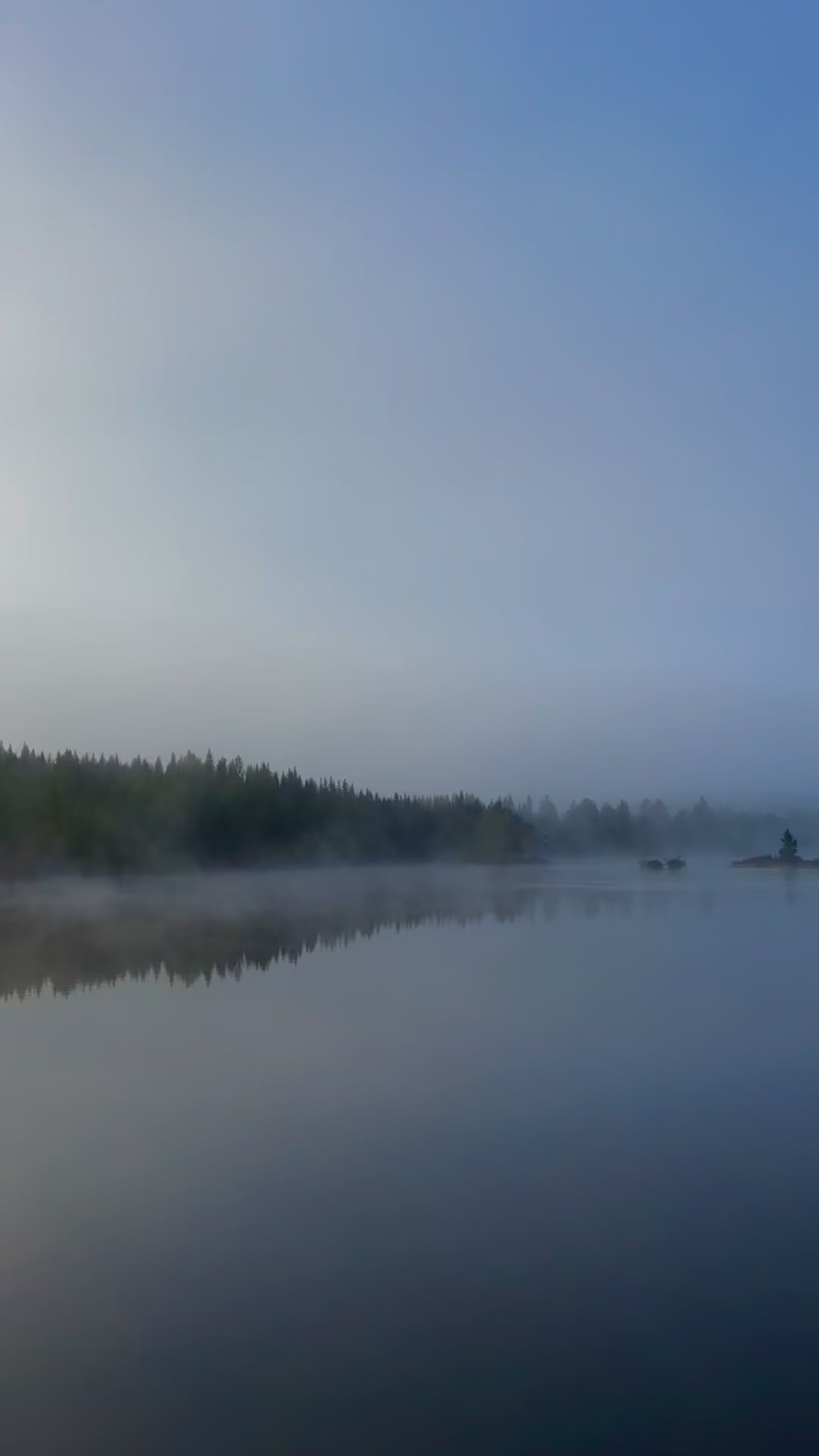 Mist over a calm lake at dawn